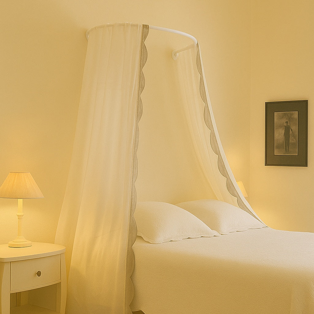 White wall-mounted canopy frame shown installed above a bed with flowing voile canopy curtains